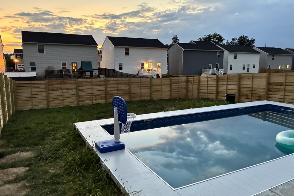 Horizontal wood privacy fence around a backyard pool